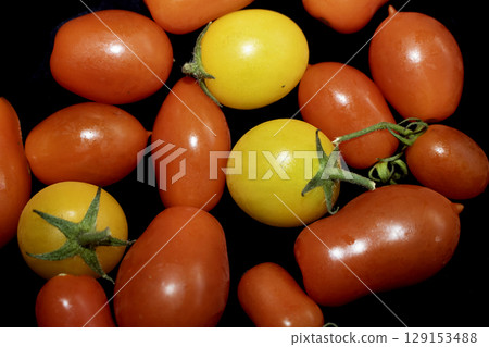 Collection of home grown tomatoes on a black background 129153488