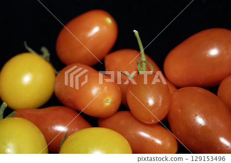 Collection of home grown tomatoes on a black background Collection of home grown tomatoes on a black background 129153496