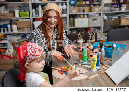 Creative Moments A Child Collaborating with an Artist in Engaging Art Activity Together 129153757
