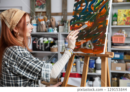 A young, innovative artist passionately painting in a vibrant and creative studio space A young, innovative artist passionately painting in a vibrant and creative studio space 129153844
