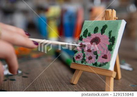 A vibrant floral painting beautifully displayed on a charming mini easel for art lovers A vibrant floral painting beautifully displayed on a charming mini easel for art lovers 129153848