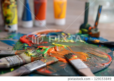 A Vibrant Artist Palette Filled with Various Colorful Paints and Brushes Ready for Use A Vibrant Artist Palette Filled with Various Colorful Paints and Brushes Ready for Use 129153849