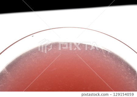 Close up abstract of a red cosmopolitan cocktail in a martini glass on white background 129154059