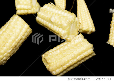 Close up of baby sweetcorn chopped on black background Close up of baby sweetcorn chopped on black background 129154074