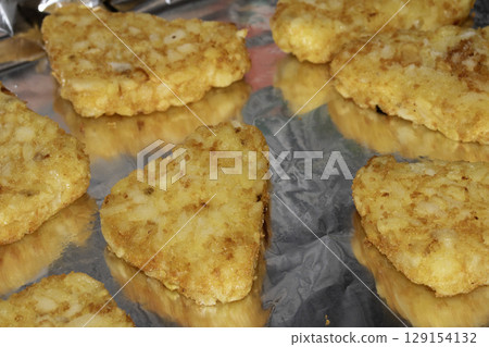 Close up of hash browns just out of the oven on tin foil 129154132