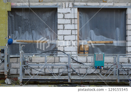 A Construction Site Featuring Unfinished Windows and Scaffolding Elements Awaiting Completion 129155545