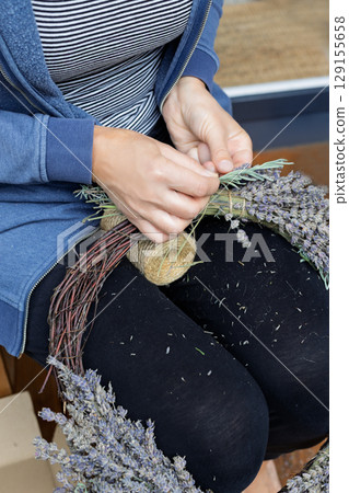 Woman Tying Lavender Stems for Handmade Wreath 129155658