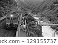 Passenger train arriving at a valley station 129155737