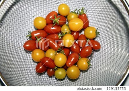 Close up of home grown tomatoes in a bowl waiting to be cooked in a colander 129155753