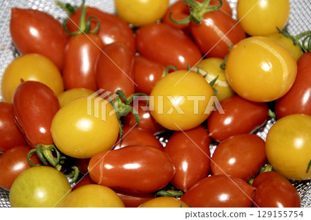 Close up of home grown tomatoes in a bowl waiting to be cooked in a colander 129155754