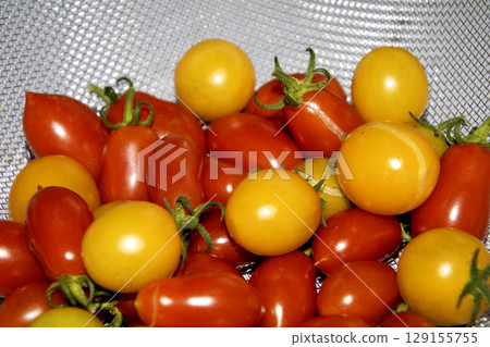 Close up of home grown tomatoes in a bowl waiting to be cooked in a colander 129155755