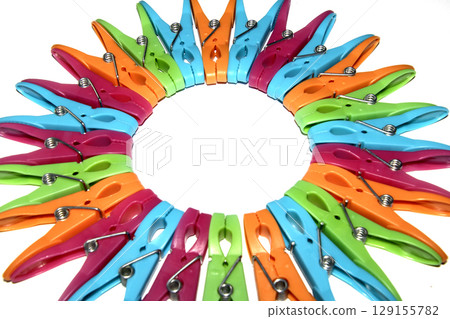 Colourful vibrant clothes pegs on a white background close up for laundry day Colourful vibrant clothes pegs on a white background close up for laundry day 129155782