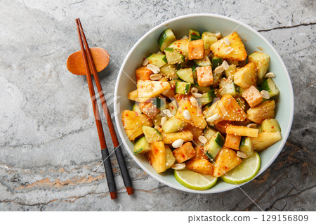 Asian Rojak fruit vegetable salad with tofu cheese seasoned with sweet and spicy sauce close-up in a bowl. Horizontal top view 129156809