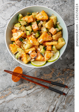 Rojak fruit vegetable salad with tofu cheese close-up in a bowl. Vertical top view Rojak fruit vegetable salad with tofu cheese close-up in a bowl. Vertical top view 129156814