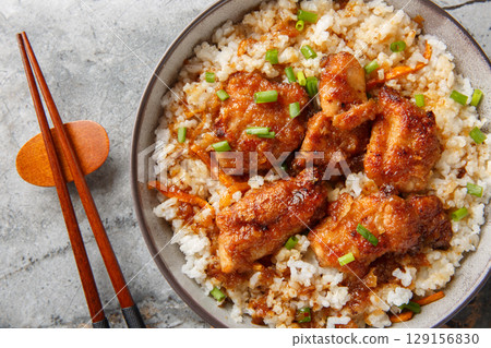 Japanese Tori Meshi chicken with rice in spicy sweet sauce close-up in bowl. Horizontal top view Japanese Tori Meshi chicken with rice in spicy sweet sauce close-up in bowl. Horizontal top view 129156830