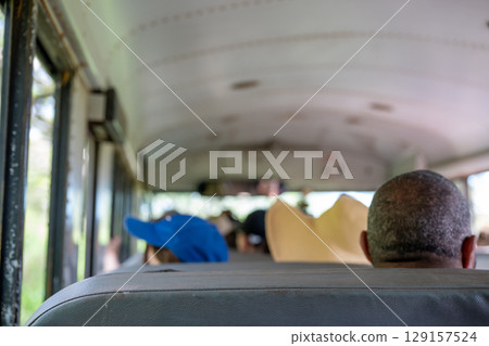 Group of people traveling on a bus in rural area during daytime 129157524