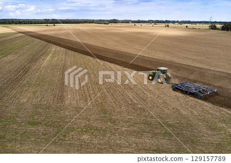 plowing farm after harvesting with vehicle plowing farm after harvesting with vehicle 129157789