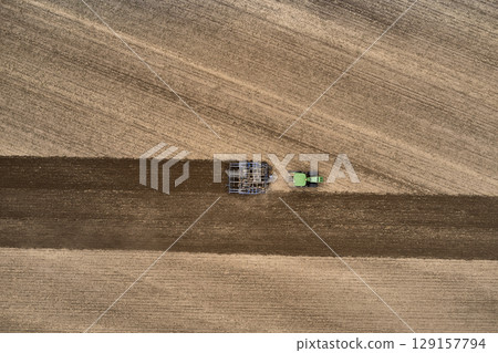 plowing farm after harvesting with vehicle plowing farm after harvesting with vehicle 129157794