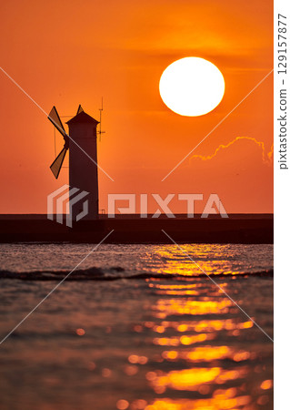 swinoujscie mills lighthouse with rising sun 129157877