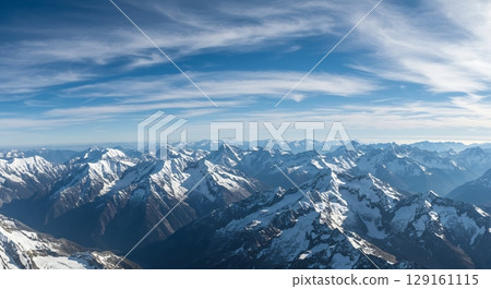 Panoramic view of snow-covered peaks, clear blue sky, majestic mountain landscape. 129161115
