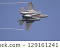 A U.S. Air Force F-35A Lightning II stealth fighter makes a sharp turn, trailing water vapor in the clear blue sky. 129161241