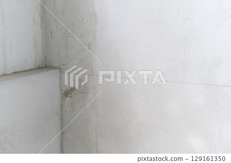 Raw concrete wall corner of house during renovation phase. An unfinished plaster surface creates texture background for construction and home improvement projects Raw concrete wall corner of house during renovation phase. An unfinished plaster surface creates texture background for construction and home improvement projects 129161350