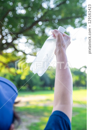 Cold water in a plastic bottle in hand, mineral water, hot summer Cold water in a plastic bottle in hand, mineral water, hot summer 129161423