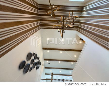 A collection of modern interior design features including contemporary lighting, wood accents, and elegant furniture. This image captures stylish details such as patterned ceilings, textured stair A collection of modern interior design features including contemporary lighting, wood accents, and elegant furniture. This image captures stylish details such as patterned ceilings, textured stair 129161667