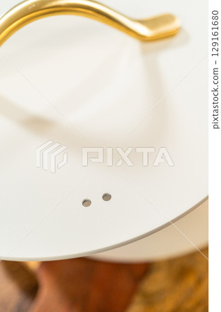 Flat lay image showing a ceramic pot lid with a golden handle, photographed against a clean white background. The lighting emphasizes minimalist kitchen styling. Flat lay image showing a ceramic pot lid with a golden handle, photographed against a clean white background. The lighting emphasizes minimalist kitchen styling. 129161680
