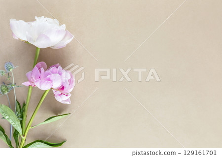 Tender, romantic flower composition with beautiful bouquet of peonies on a craft background with copy space. Vintage holiday bouquet. Flower card. Soft focus style image 129161701