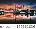 Harbor Evening with Moored Sailboats and Overcast Sky in the Evening Light 129161836