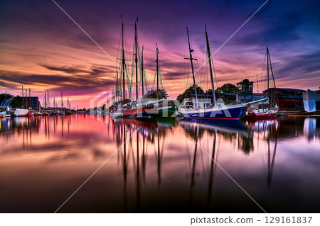 Harbor Evening with Moored Sailboats and Overcast Sky in the Evening Light Harbor Evening with Moored Sailboats and Overcast Sky in the Evening Light 129161837