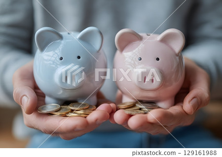 Blue and pink piggy banks are presented with various coins, signifying the act of diligently saving money for the future. 129161988