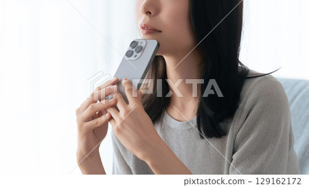 一位女士用智慧型手機思考 一位女士用智慧型手機思考 129162172