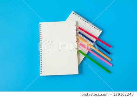 Top view of notebook and color pencil on background. 129162243