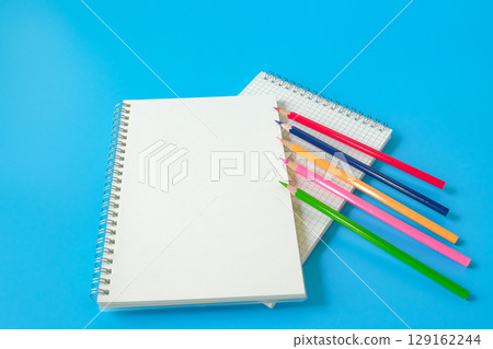 Top view of notebook and color pencil on background. 129162244