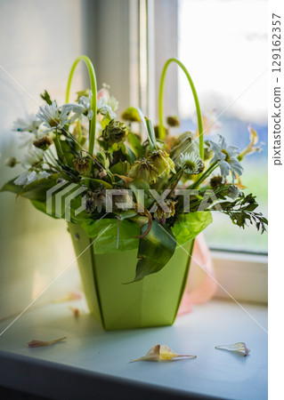 Wilted dried bouquet on the windowsill 129162357