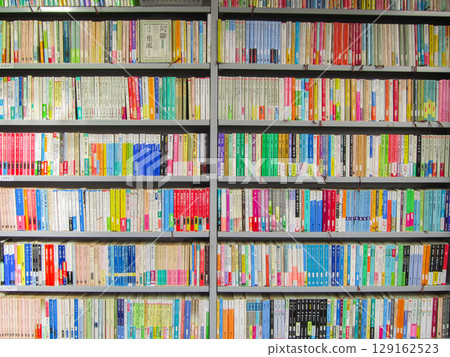 Books lined up on bookshelves 129162523