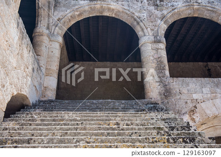 Historic stone courtyard with arched staircases, ancient sculptures in a Mediterranean old town Historic stone courtyard with arched staircases, ancient sculptures in a Mediterranean old town 129163097