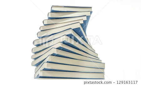 Blue-covered books stacked in a spiral on a white background Blue-covered books stacked in a spiral on a white background 129163117