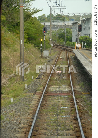 A rural train station platform with tracks 129163475