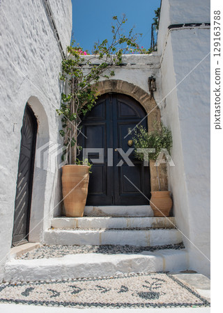 White buildings with flowers in Lindos on Rhodes island, Greece White buildings with flowers in Lindos on Rhodes island, Greece 129163788