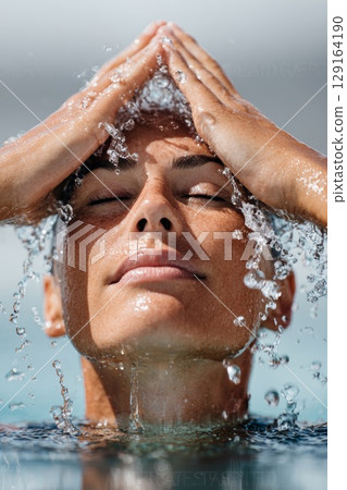 Diver emerging from water, water droplets cascading, showcasing athleticism and focus in springboard diving Diver emerging from water, water droplets cascading, showcasing athleticism and focus in springboard diving 129164190