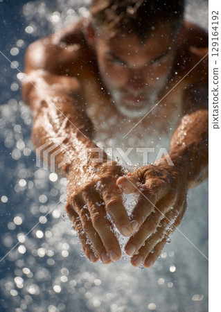 Diver executing a springboard dive with water splashing around in a dynamic and energetic scene Diver executing a springboard dive with water splashing around in a dynamic and energetic scene 129164192