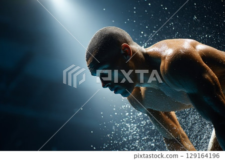 Male diver preparing for springboard dive, showcasing focus and determination in water splashes 129164196