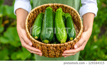 Woman holding a zucchini 129164315