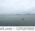 Aerial perspective of a tugboat and cargo ships in the vast South China Sea off Hong Kong 129165060