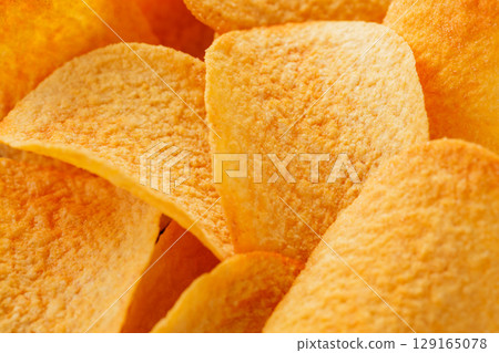 Close-Up of Golden Potato Chips with Oily Texture and Flavor Close-Up of Golden Potato Chips with Oily Texture and Flavor 129165078