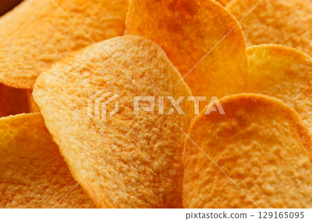 Close-Up of Golden Potato Chips with Oily Texture and Flavor Close-Up of Golden Potato Chips with Oily Texture and Flavor 129165095