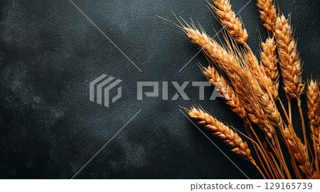 Golden Wheat Ears on Dark Rustic Background 129165739